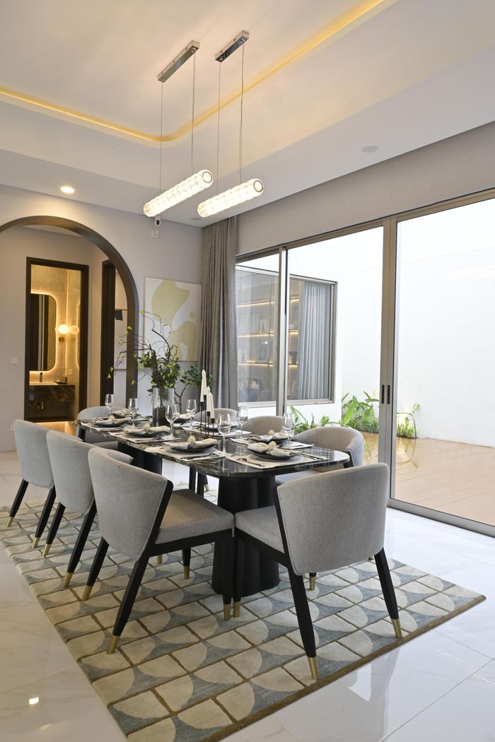 Luxurious dining room setup with elegant furniture, bright lighting, and contemporary decor.