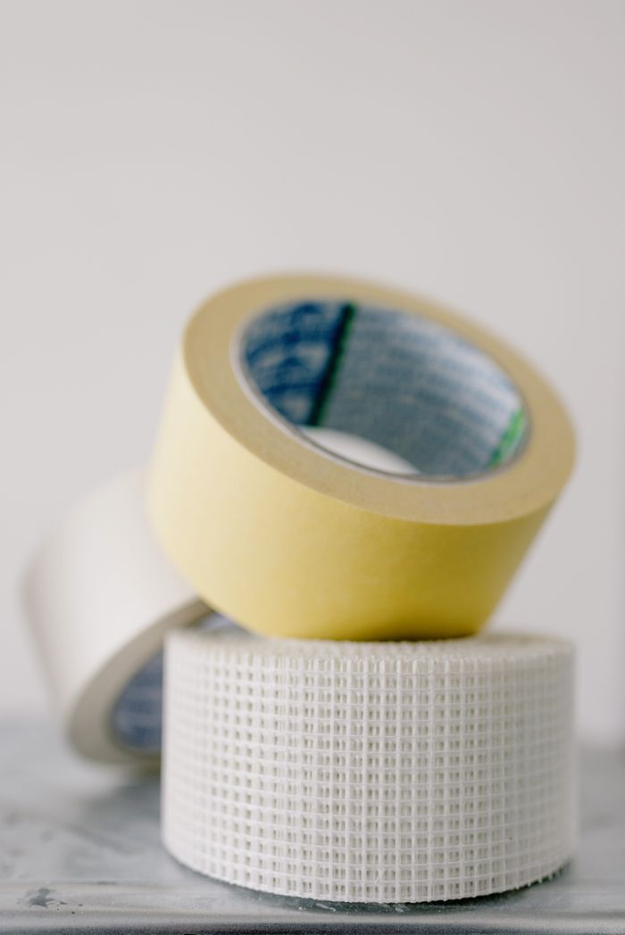 Various types of masking tapes on marble table near white wall at home